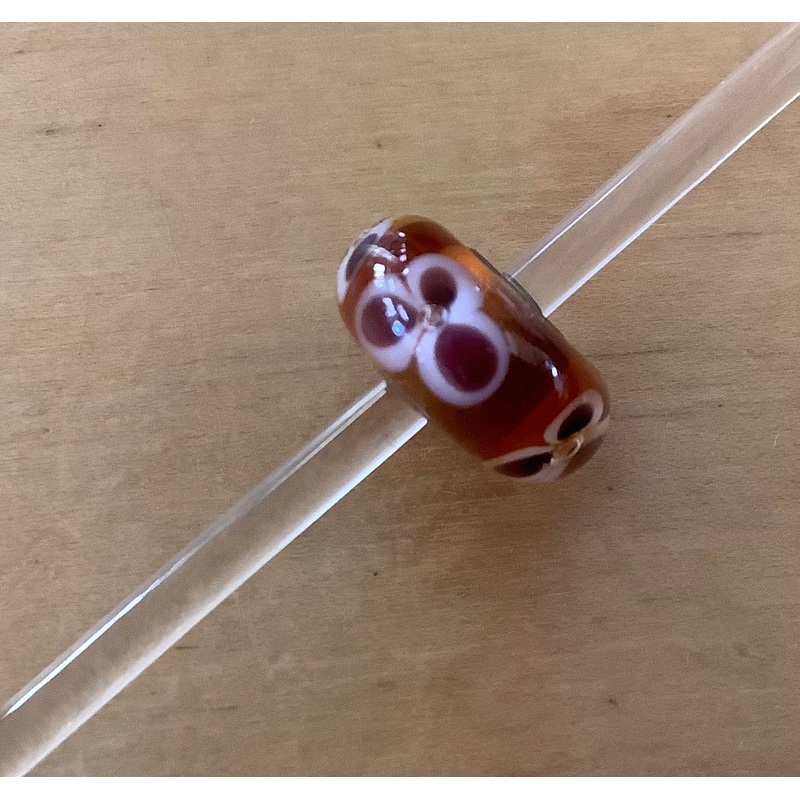 Unique Trollbead amber w/ mauve and white flower